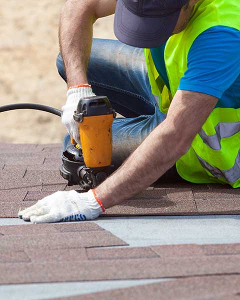 Guy installing asphalt shingle roofing